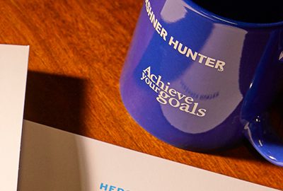 Letterhead and a coffee mug featuring Hershner Hunter branding