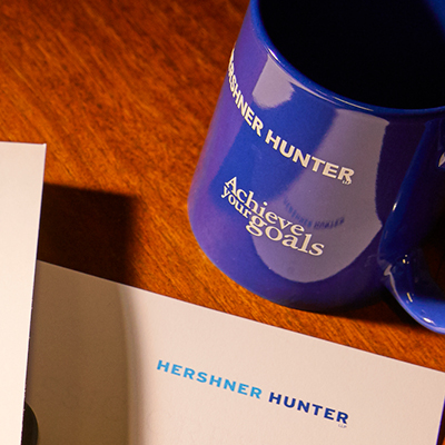Letterhead and a coffee mug featuring Hershner Hunter branding