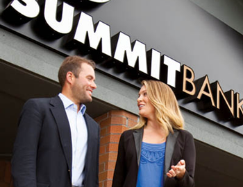 Two team members in front of a Summit Bank Branch