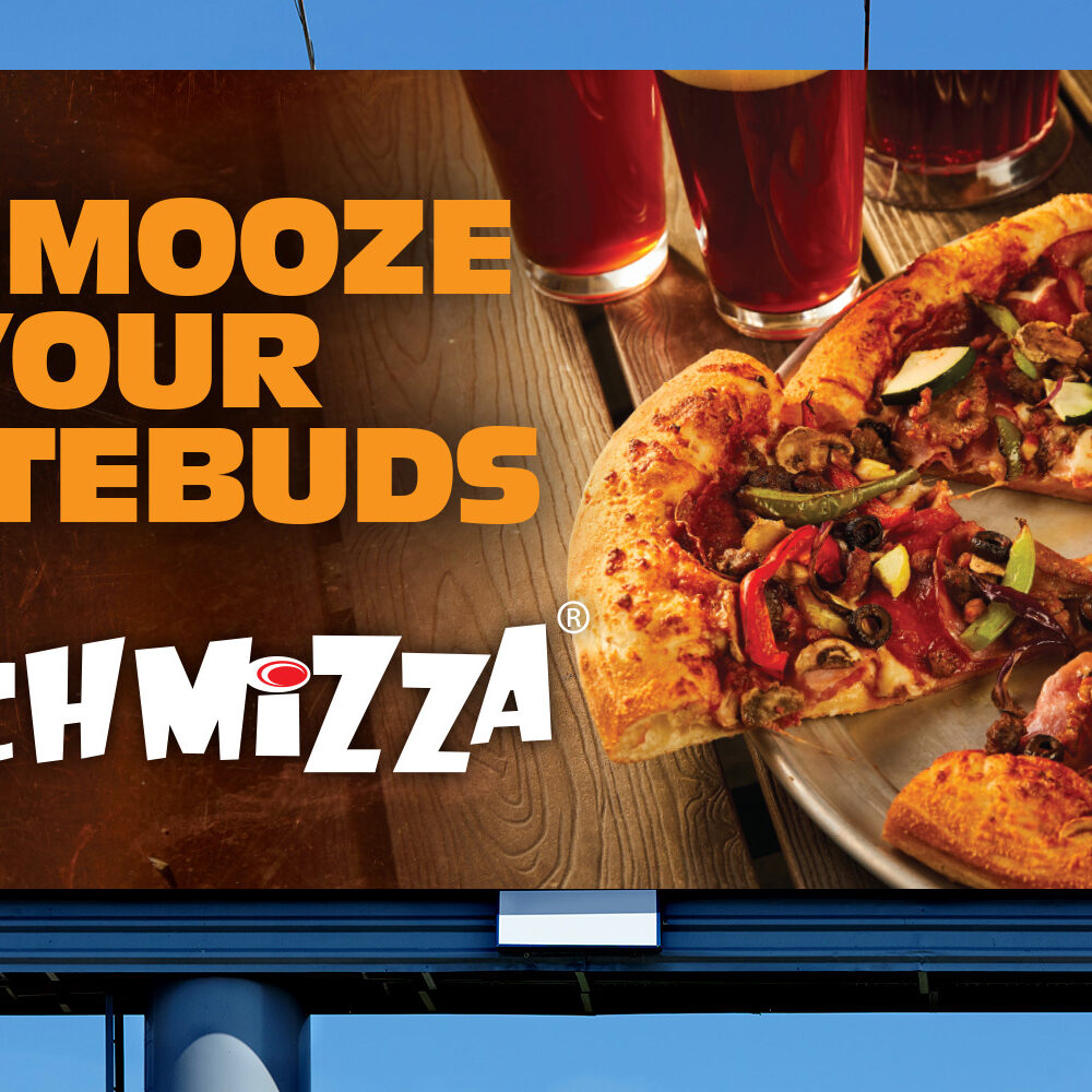 "Schmooze Your Tastebuds" with a Schmizza logo on a billboard